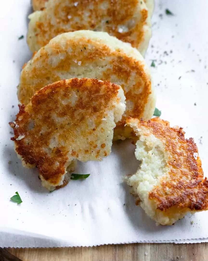 A potato pancake broken in half.