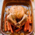 Roasted chicken with carrots in a roasting pan