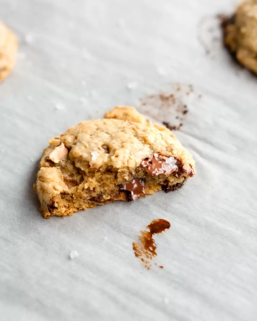A half of a chocolate chip cooked on a sheet pan.