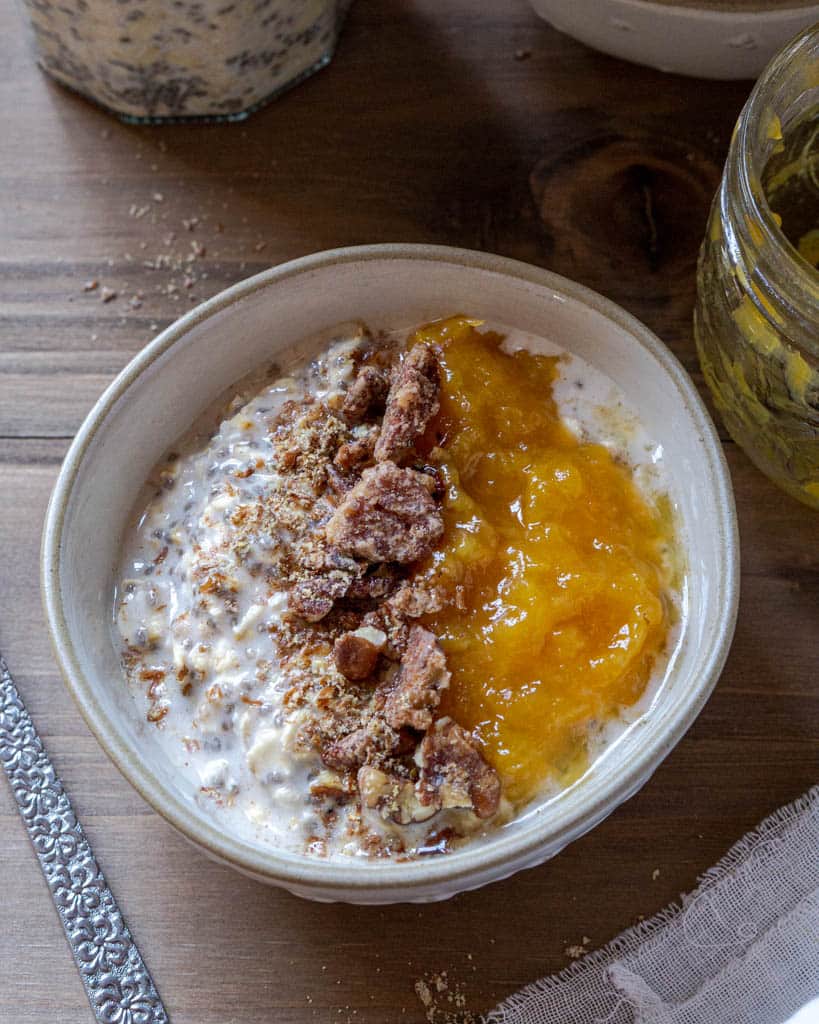 A bowl of overnight oats jam and candied nut topping