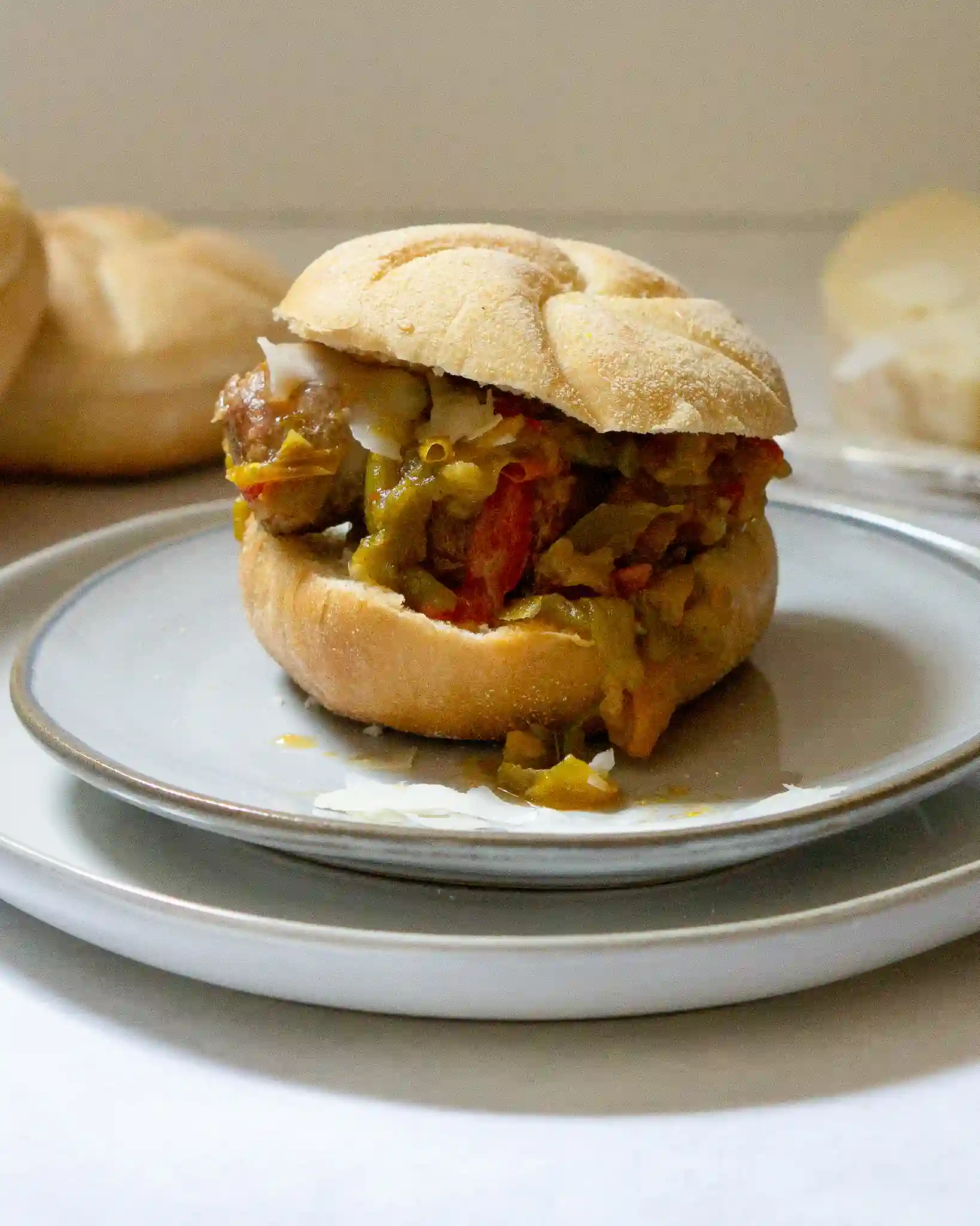 a kaiser roll with sausage and peppers