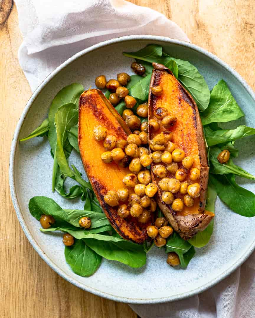 roasted sweet potato on a bed of greens topped with roasted chickpeas