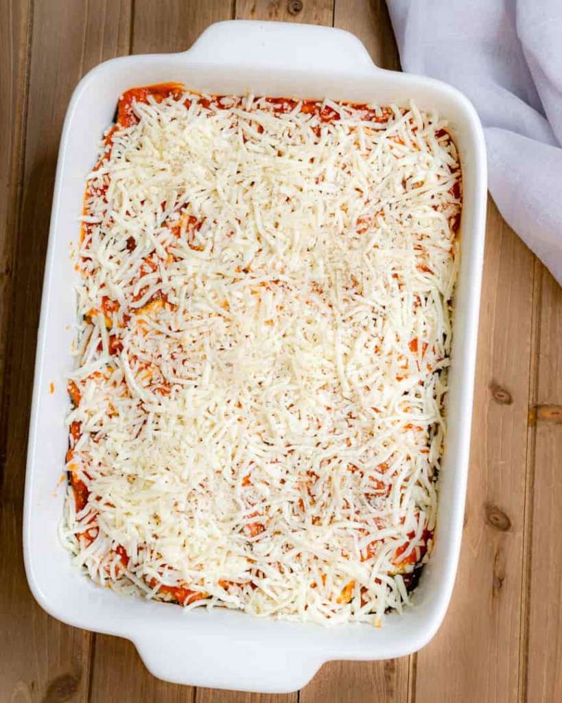 A unbaked casserole pan with a cheese topping.