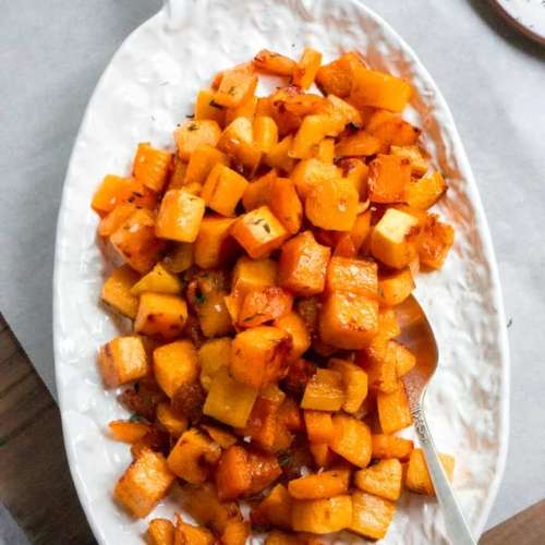 Roasted butternut squash cubes on a plate with a spoon