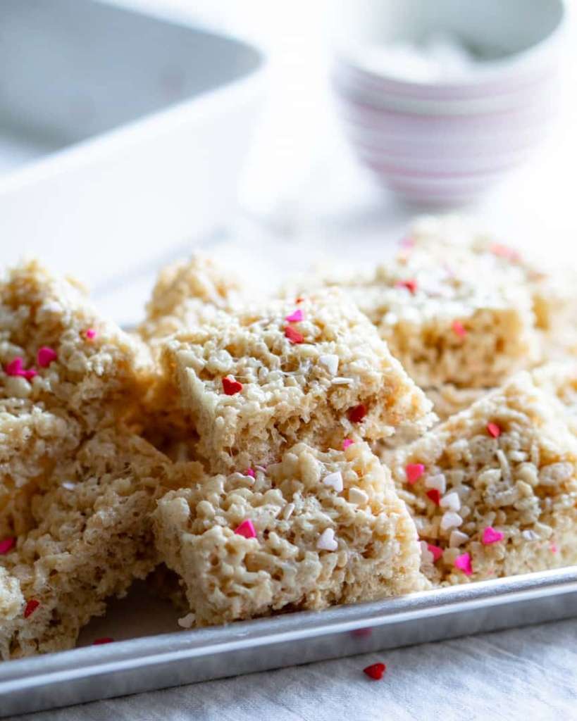 A tray of rice krispie treats with heart sprinkles