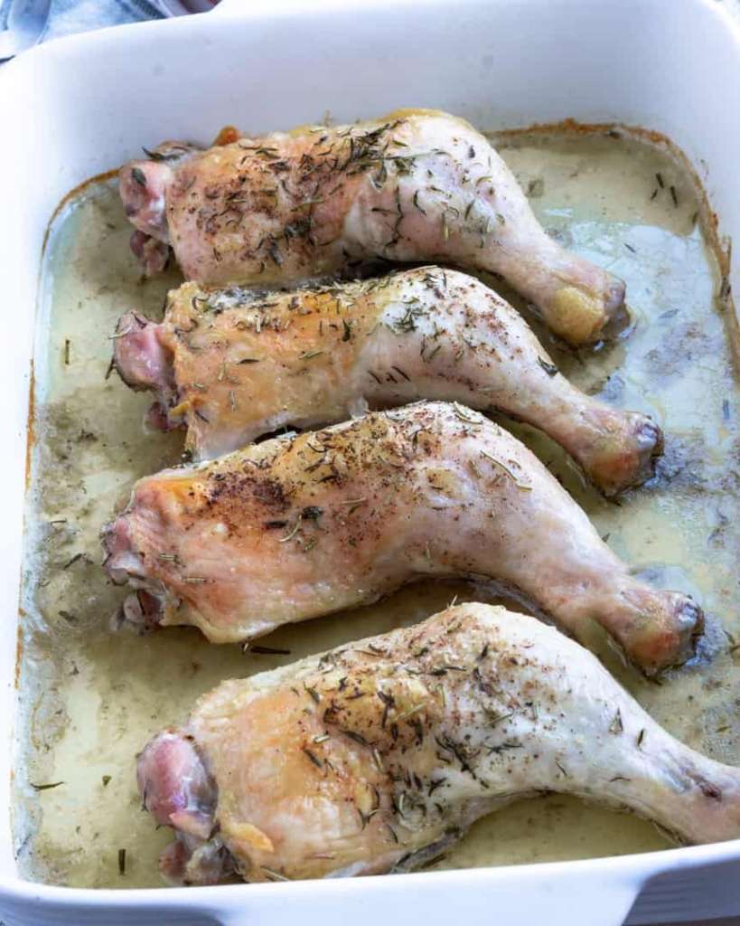 Roasted chicken quarters in a baking pan