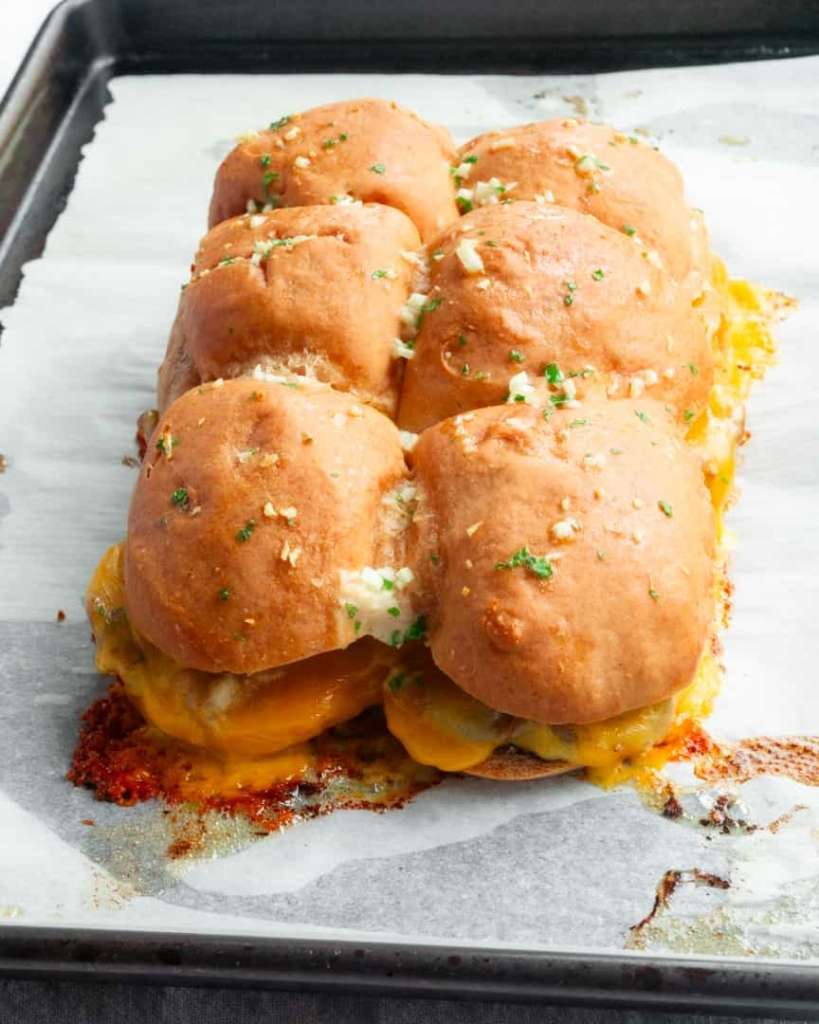 Baked slider buns filled with roast beef and melted cheddar cheese.