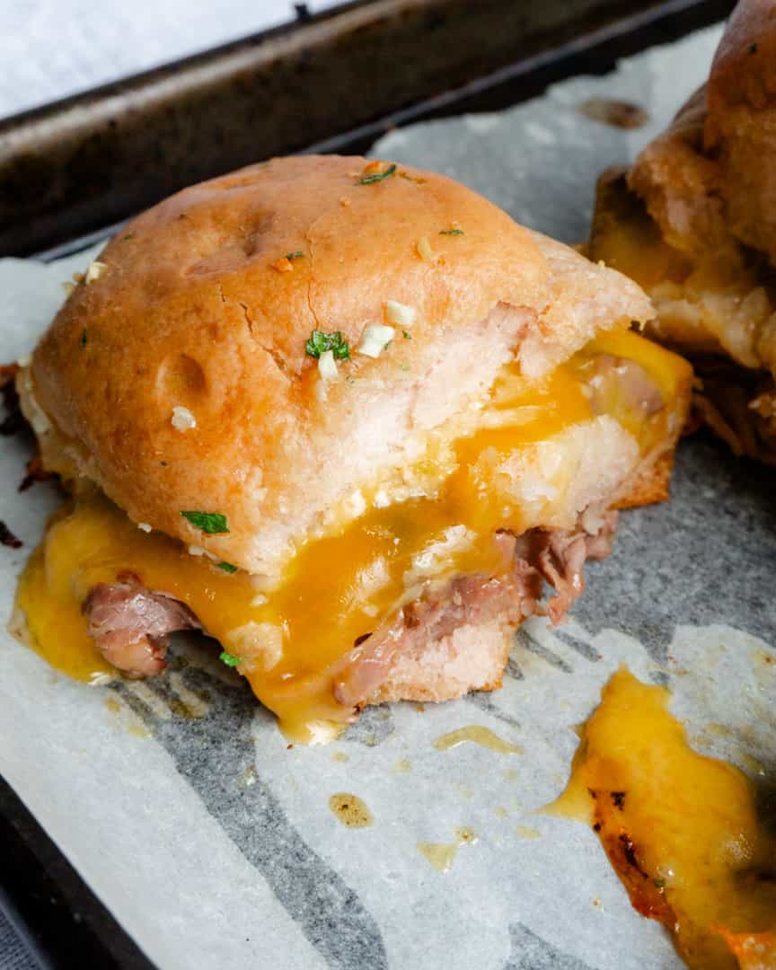 A slider bun with roast beef and melted cheese.