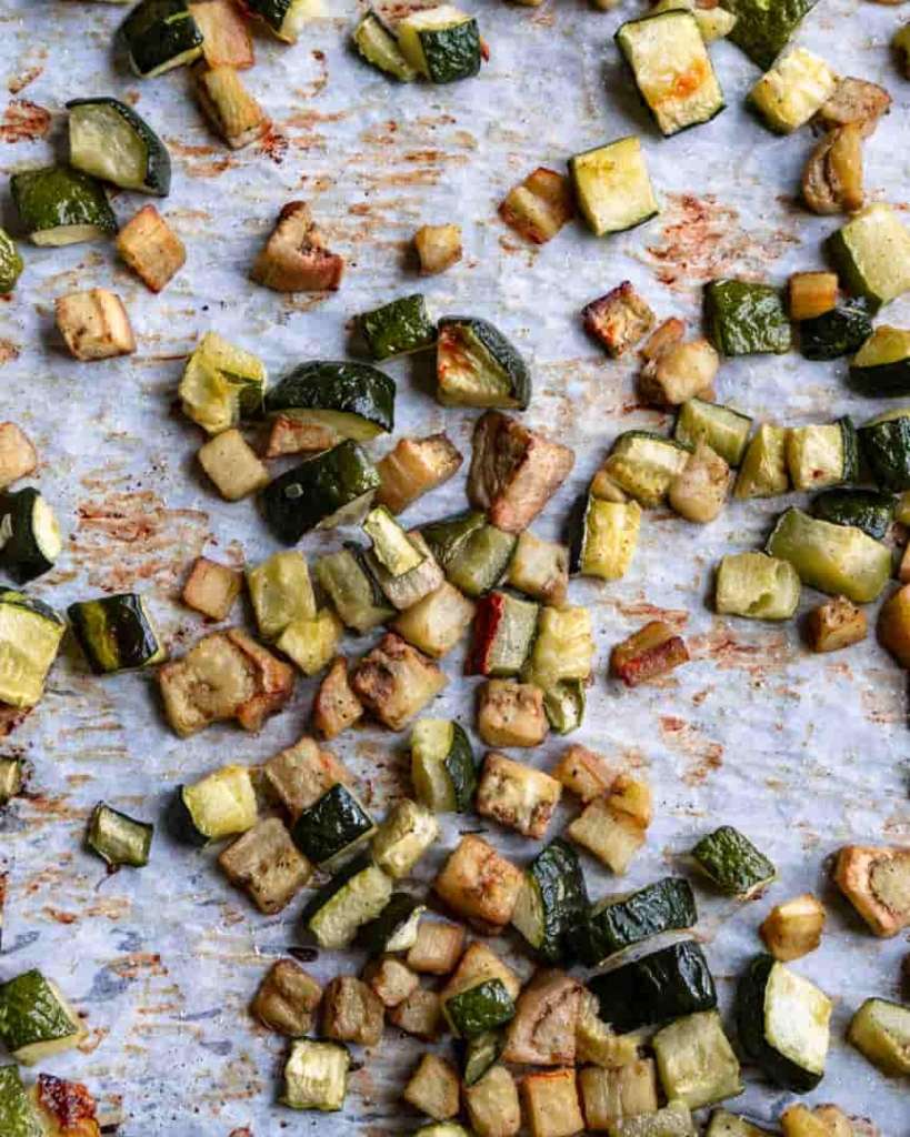 Roasted zucchini and eggplant cubes on a baking sheet.