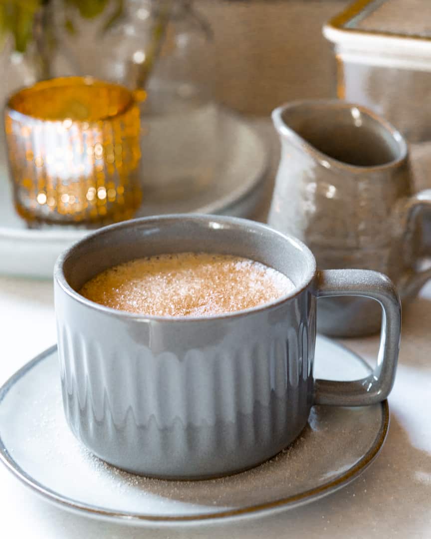A mug of tea with cinnamon on top