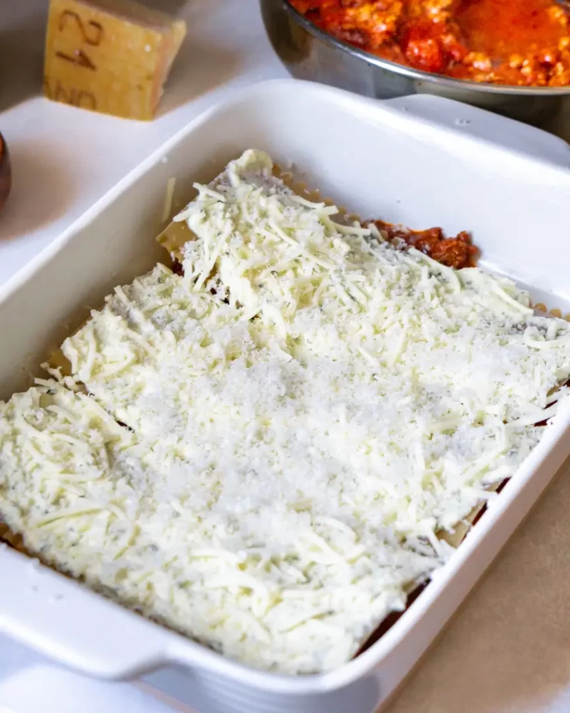Unbaked lasagna noodles covered in mozzarella cheese