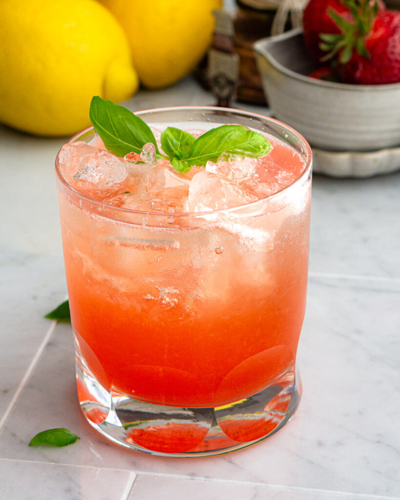 A glass of strawberry basil spritzer.