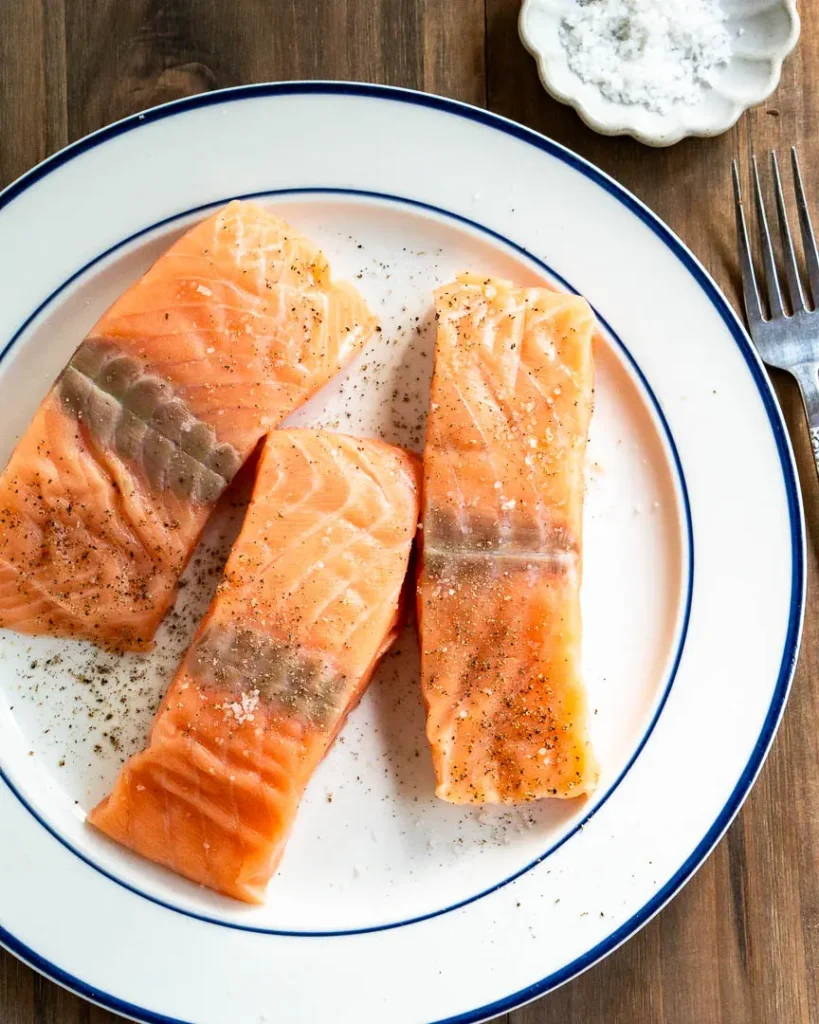 Uncooked salmon fillets on a plate.