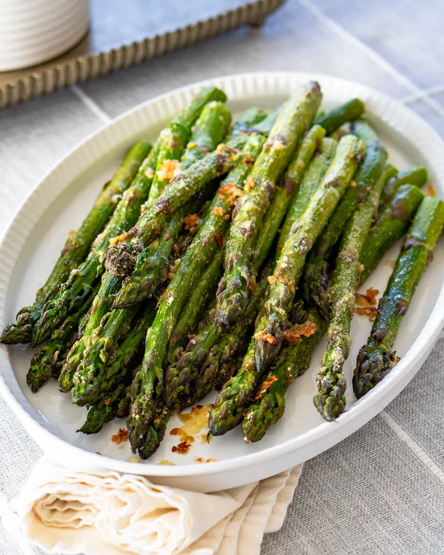 Roasted asparagus with parmesan cheese on a platter.