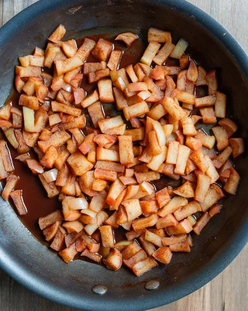Chopped cooked apples in a sauté pan.