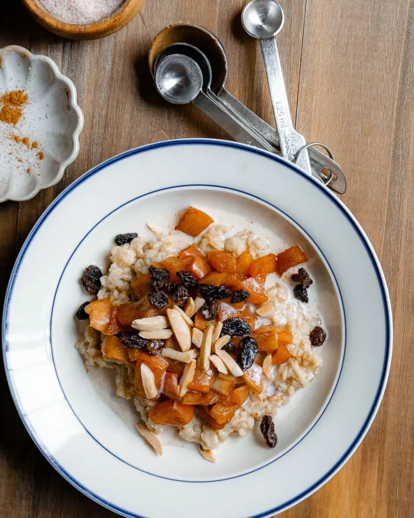 A bowl of cinnamon apple oatmeal with toppings.