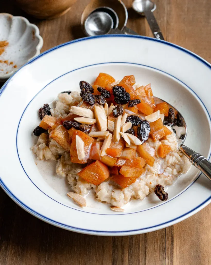 A bowl of apple cinnamon oatmeal with toppings.
