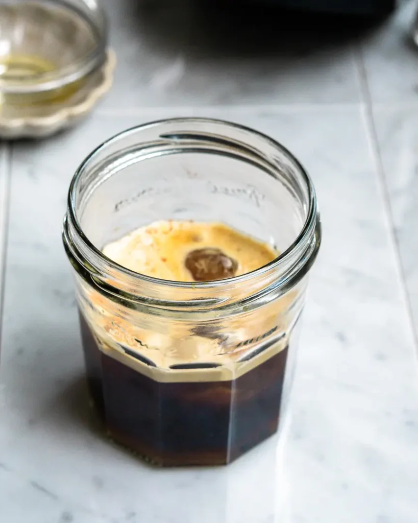 A jar filled with coffee and ice.