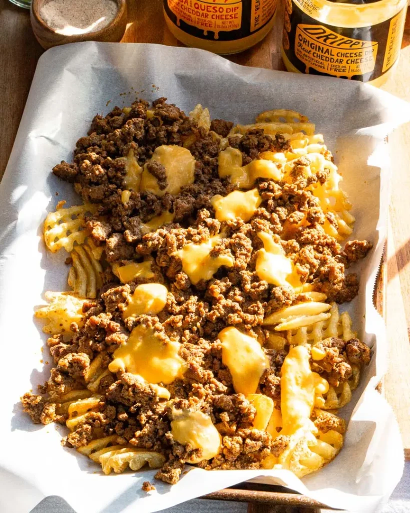 Melted cheese over ground beef and waffle fries.