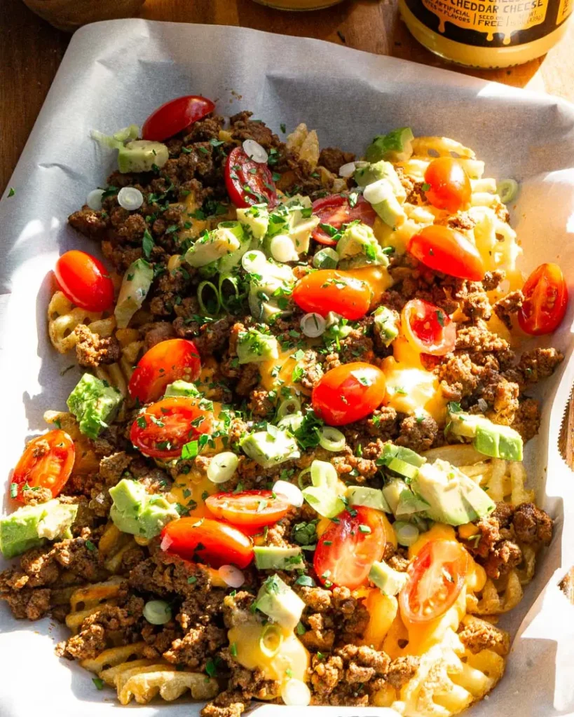 A serving tray with loaded waffle fries on it.