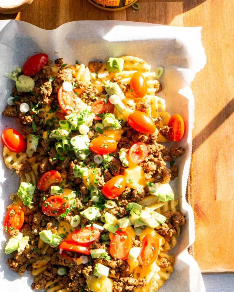 Loaded waffle fries topped with ground beef, tomatoes, green onions, avocado, cheese.